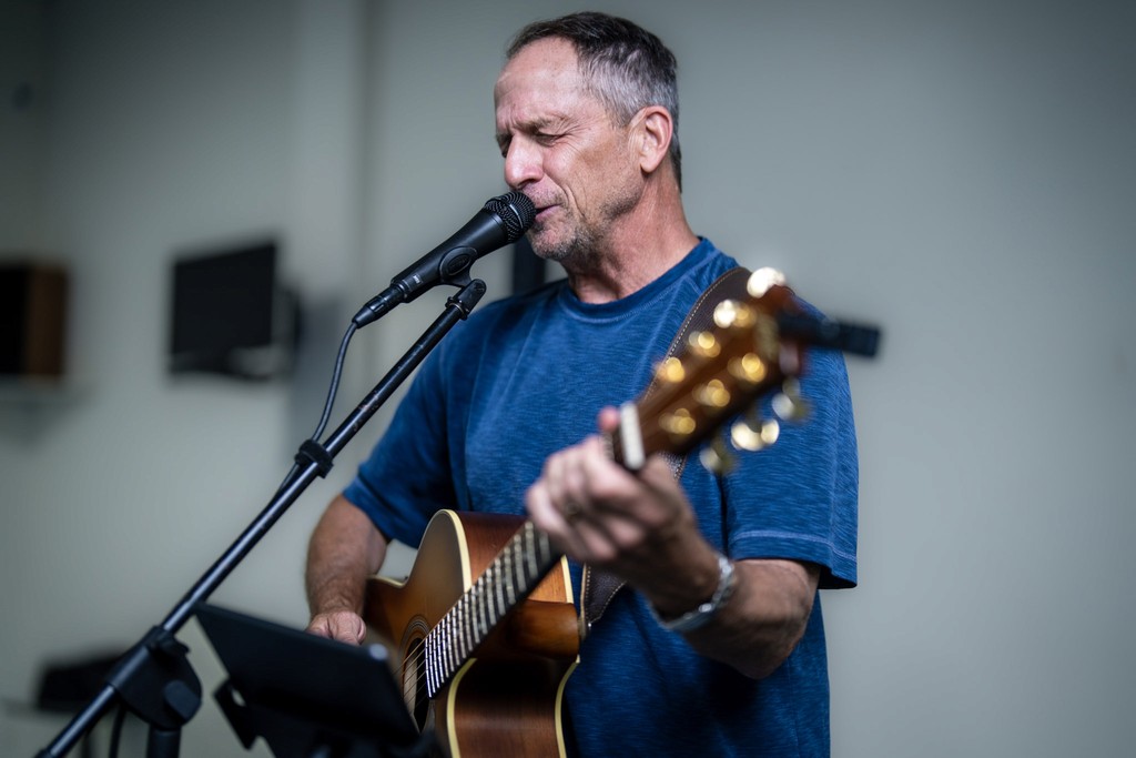 A calm pond surrounded by grass with mountains in the distance