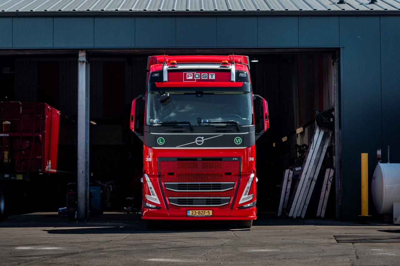 Dieplader transport in rode Volvo post handel en transport