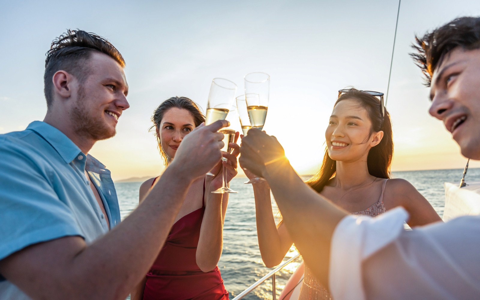 Przyjaciele wznoszący toast prosecco na rejsie o zachodzie słońca po rzece Gdańskiej.