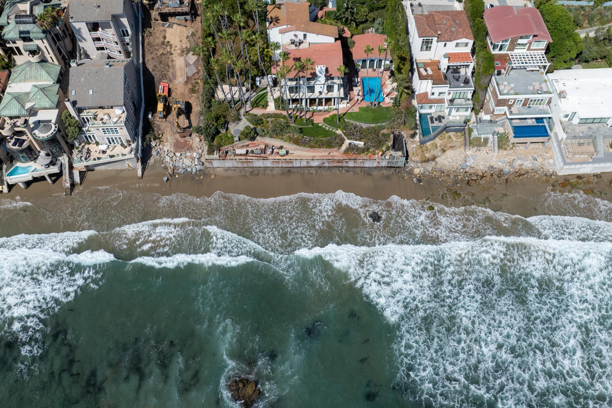 Aerial view of Malibu coastline showing custom homes and ongoing rebuilding projects by ARCA Builders after the Pacific Palisades fires subject to coastal commissions regulations.