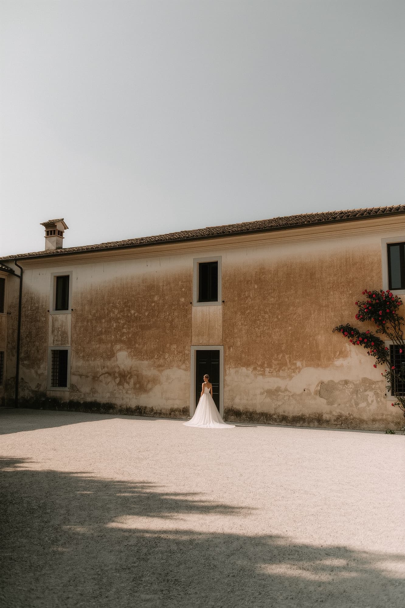 Rustic stone wedding venue exterior with arched entrance in warm afternoon light