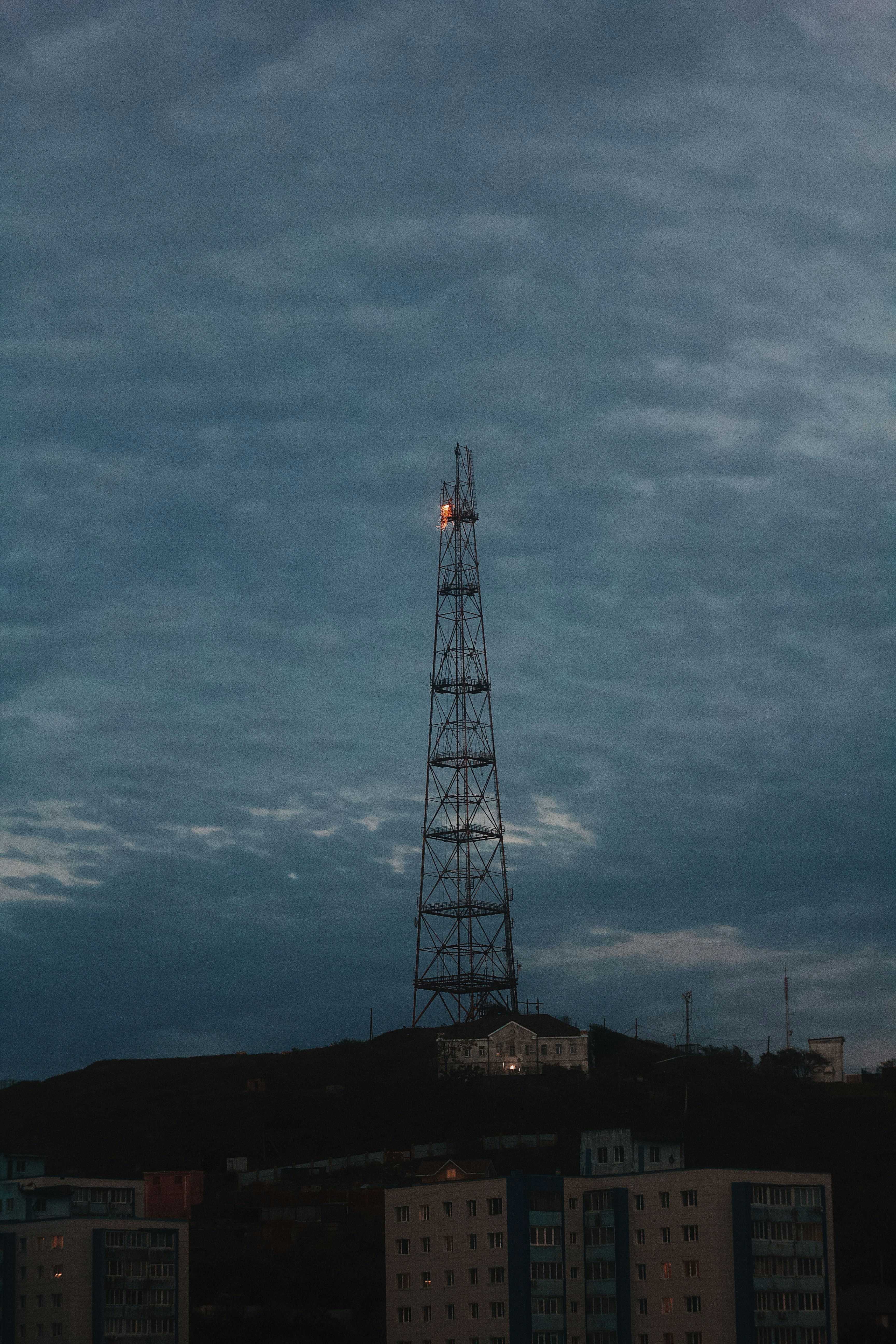 Tall radio tower on a hill at dusk