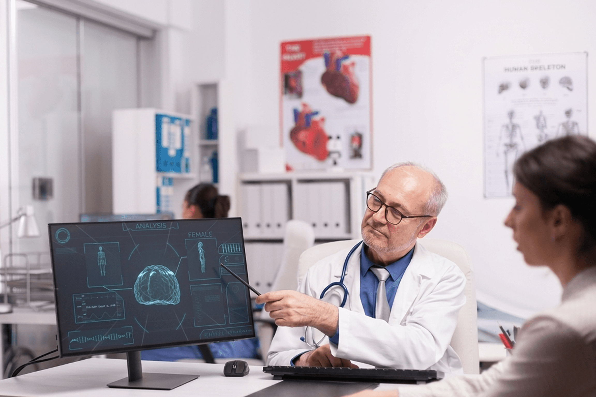 Doctor reviewing AI-driven clinical analytics on a monitor with a patient, representing healthtech teams building AI-enabled healthcare products in 2026.