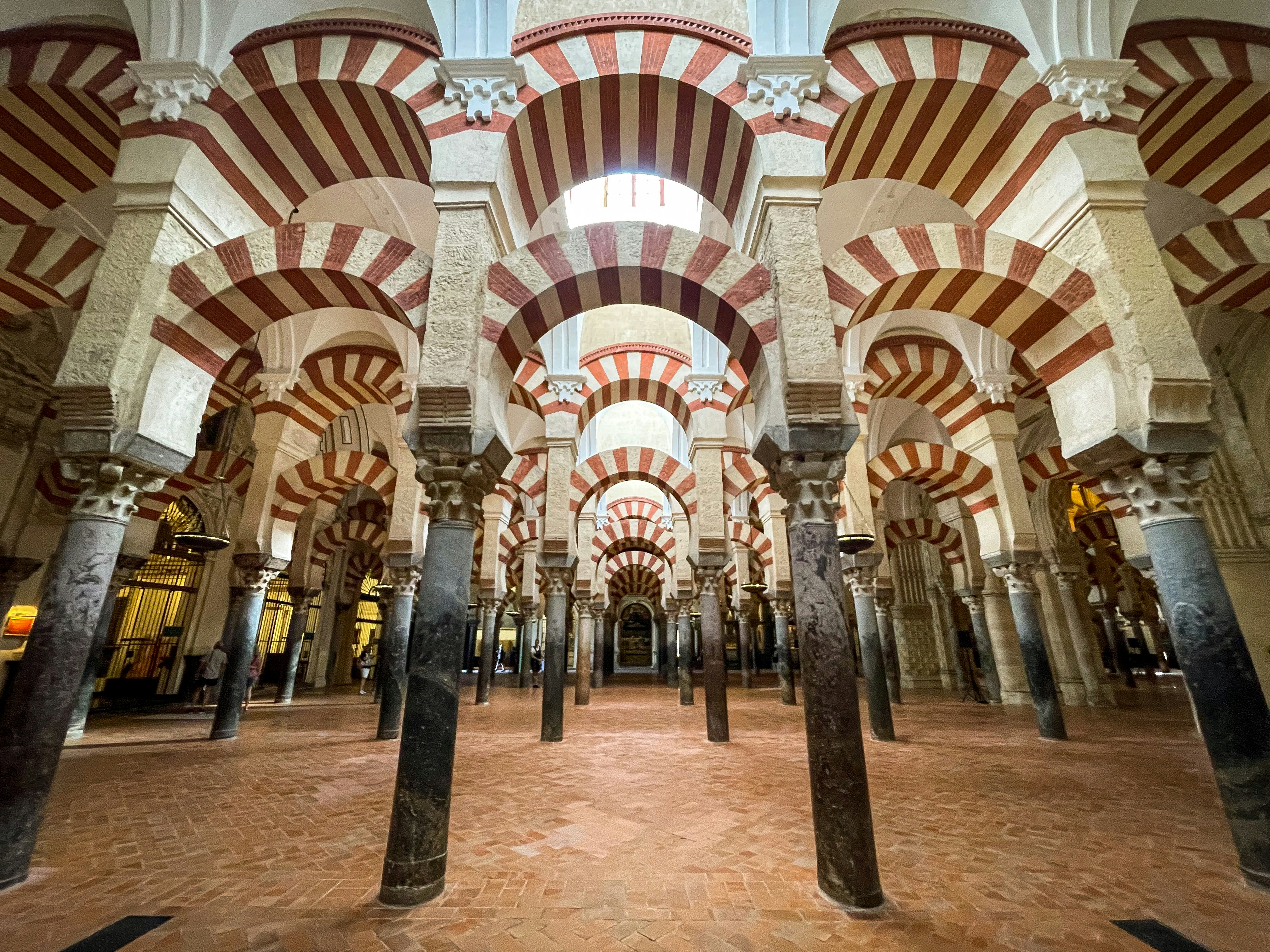 the inside of a building with columns and arches