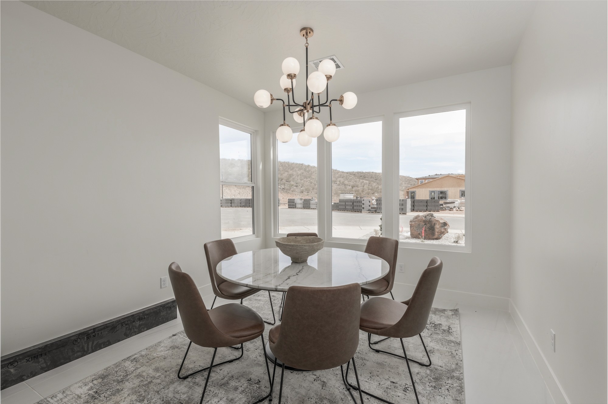 Dining room in a custom home in Southern Utah with a unique chandelier over a round dining table. 
