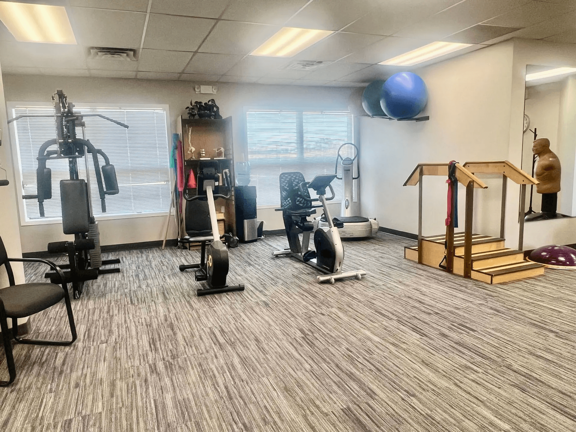 Cardiovascular rehabilitation area at Advantage Physical Therapy featuring a professional treadmill, recumbent bike, and balance training equipment.