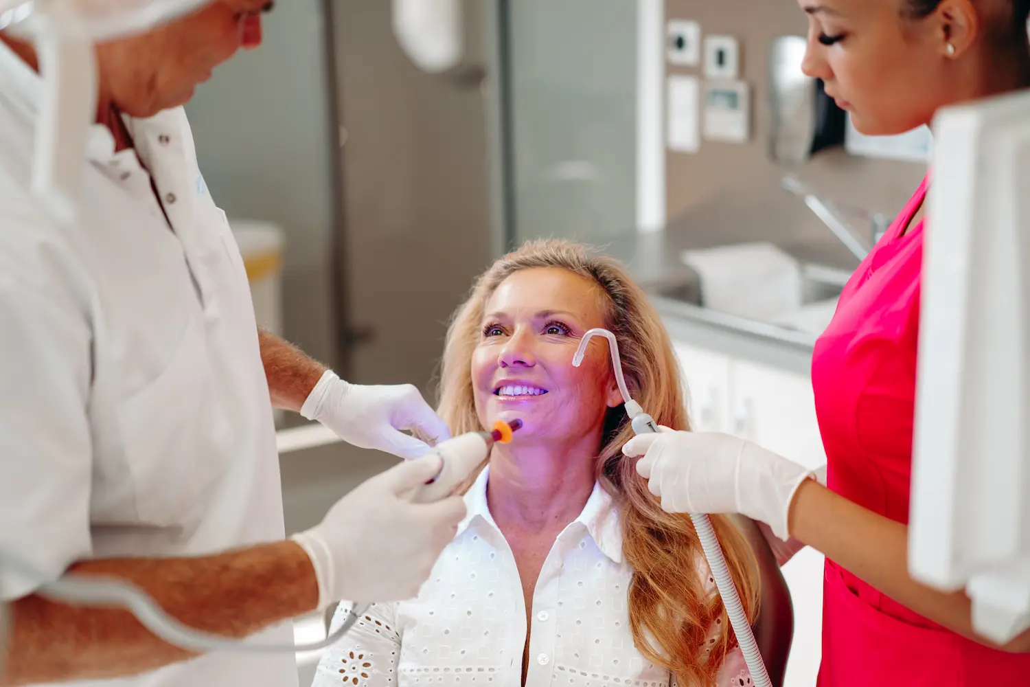 Fiatal szemüveges páciens fogászati laborban, egészséges mosolyal. 