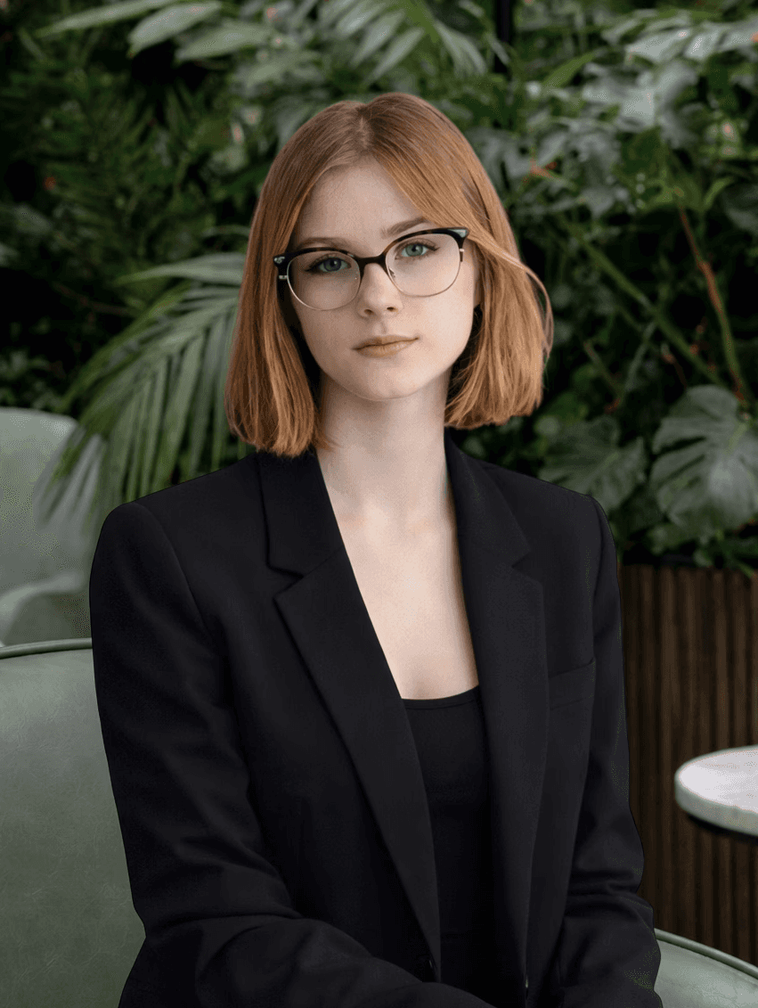 Casual studio portrait of a bearded man with curly hair in a white shirt, arms crossed, on a light gray background.
