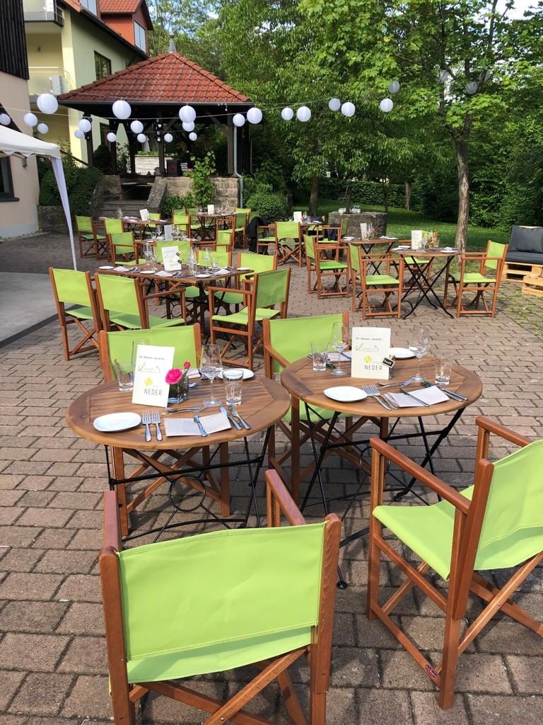 Bestuhlter Weingutshof mit grünen Akzenten für Kaffee und Kuchen unter freiem Himmel.