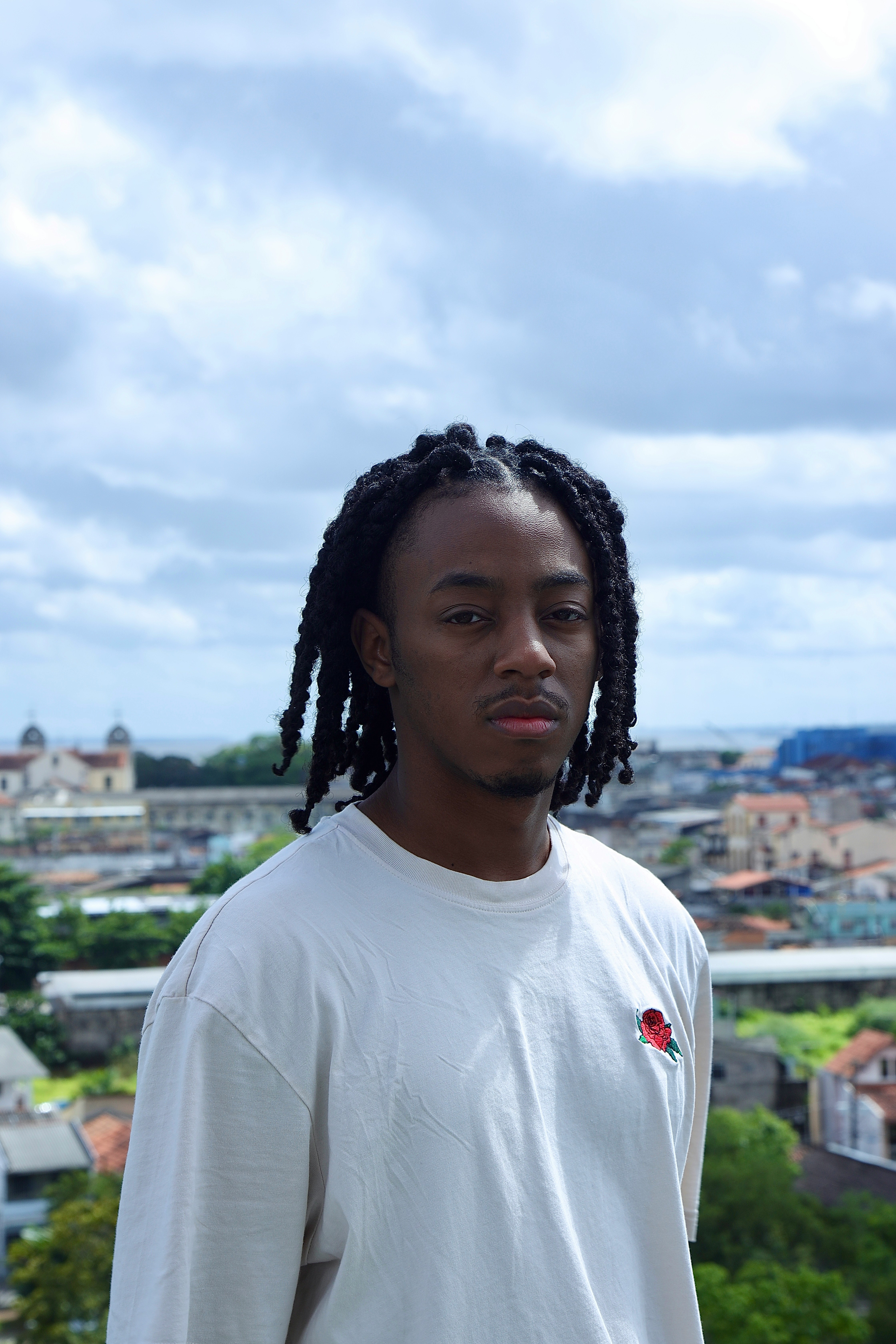 A young man poses against a city skyline.