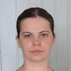 a woman with her arms crossed posing for a picture