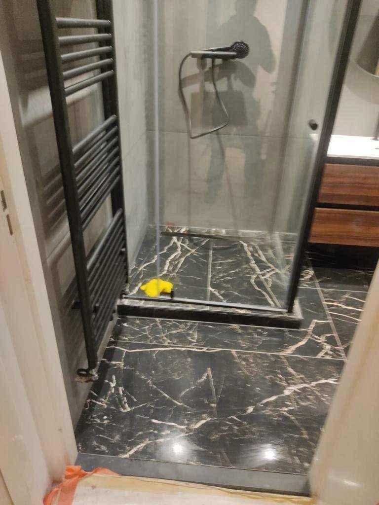 Petit WC/salle d’eau style classique : carrelage métro blanc, sol chevrons, vasque ronde, miroir ornemental.