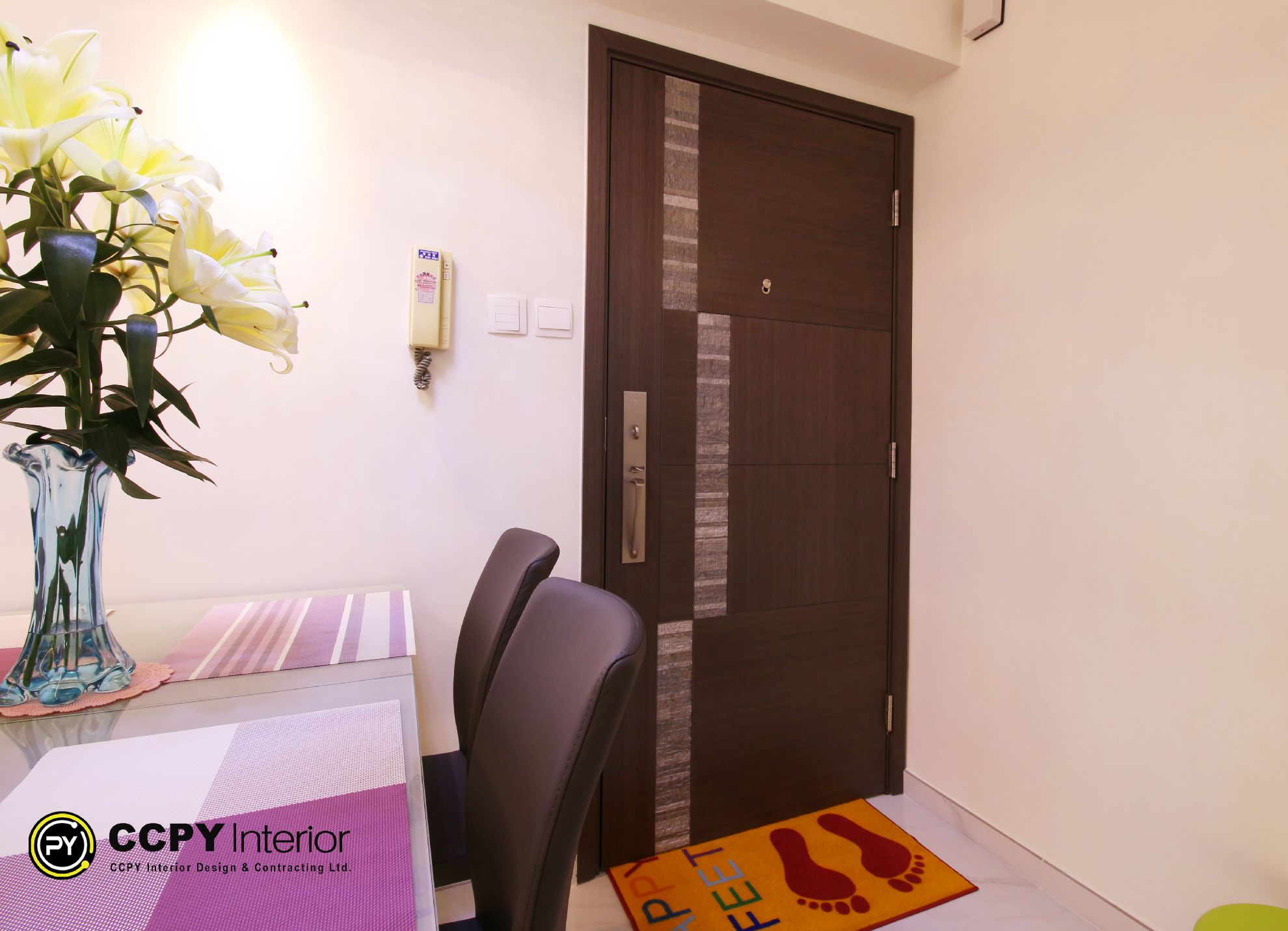 Chic foyer renovation in Mount Pavilia with classic black and white checkerboard marble flooring and a deep navy entrance door.