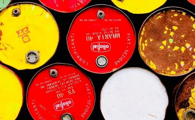 This is an image showing oil barrels in bright red and yellow colors stacked upon each other with four in the bottom and three on top. 