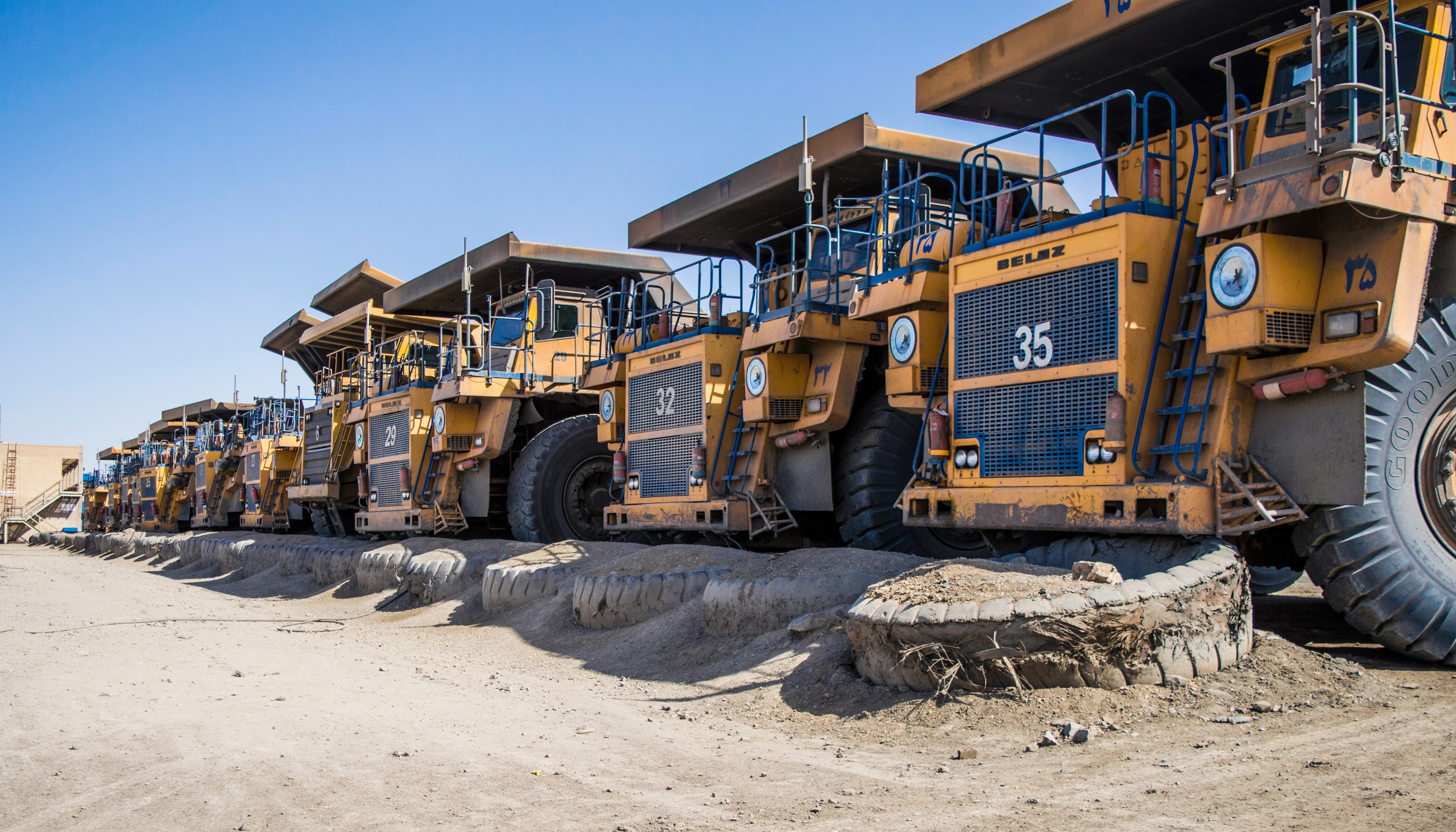 a row of large yellow trucks parked next to each other