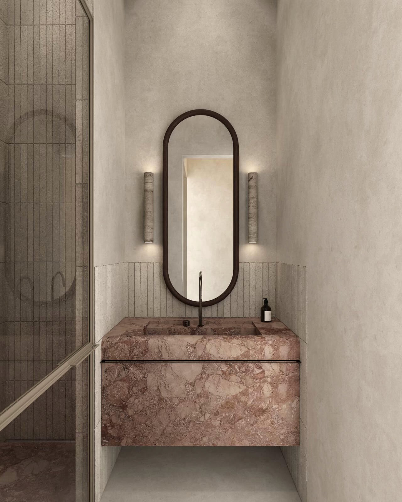 A close-up of a refined bathroom design, with a pink marble sink and carefully curated lighting that enhances its elegance