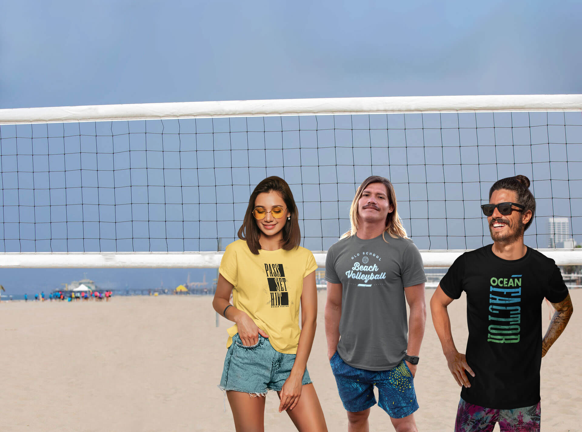 Two male models and one female model modeling beach volleyball tshirts on the beach infront a beach volleyball net