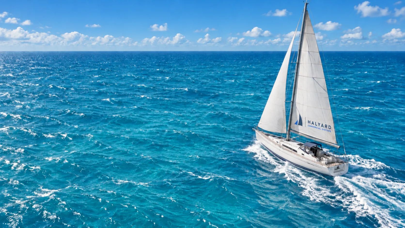 White sailing boat cutting through clear turquoise Caribbean water