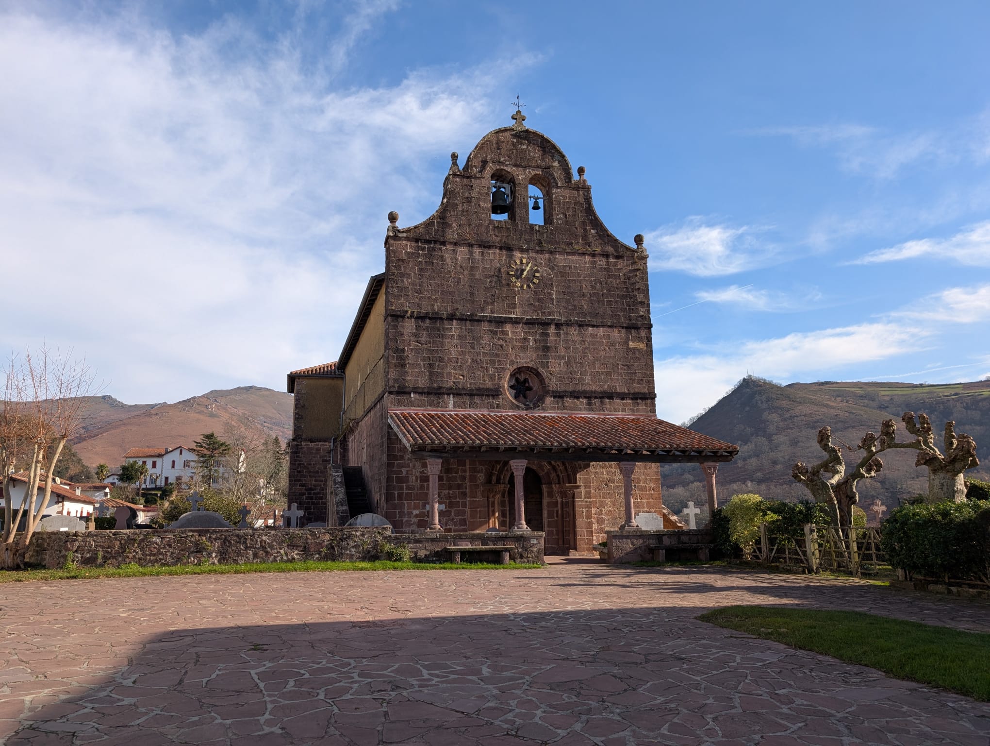 Vibrant pink and purple sunset colors reflected across serene ocean waves and sandy path.
