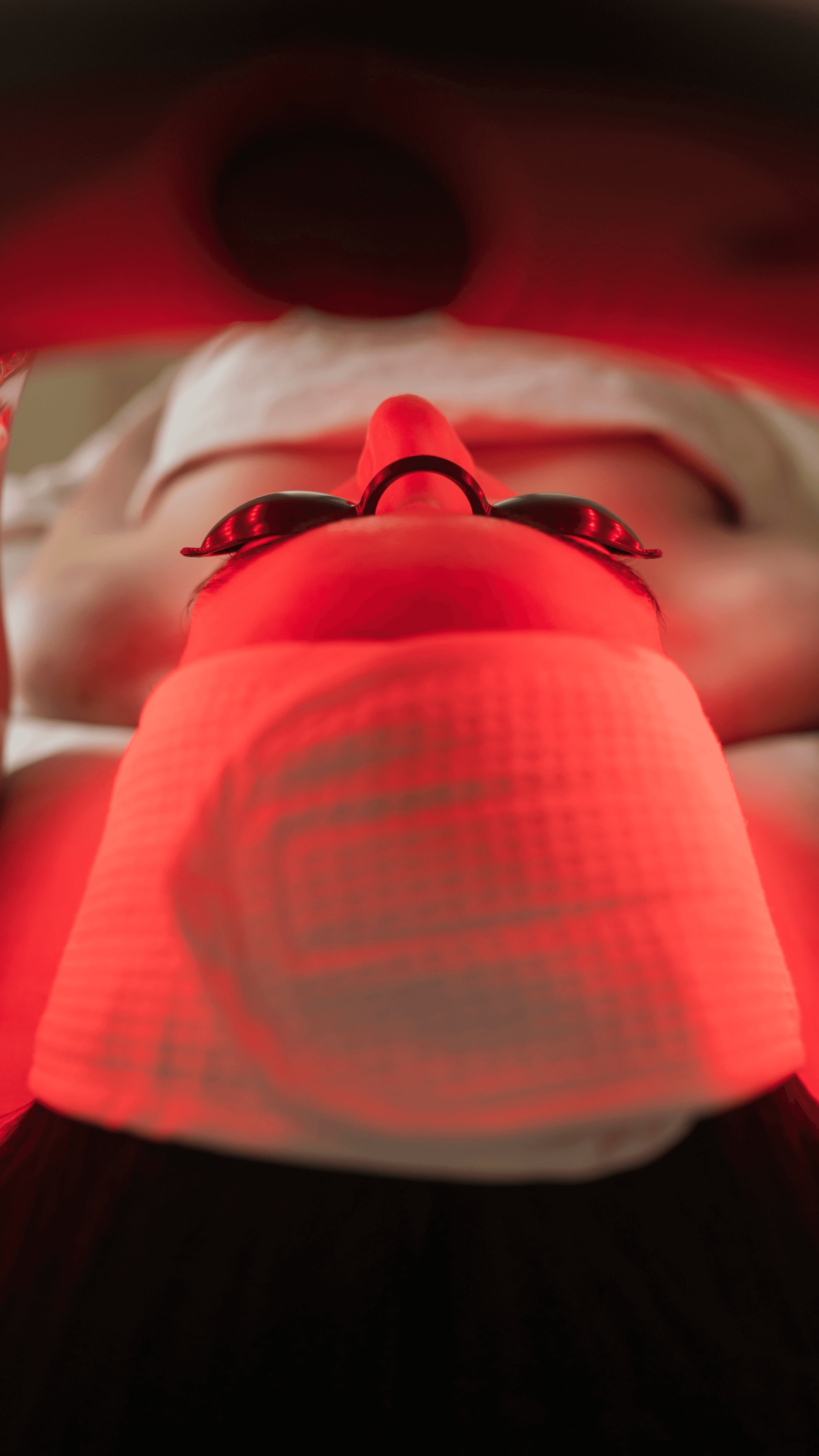 Woman receiving facial treatment with metal tools.