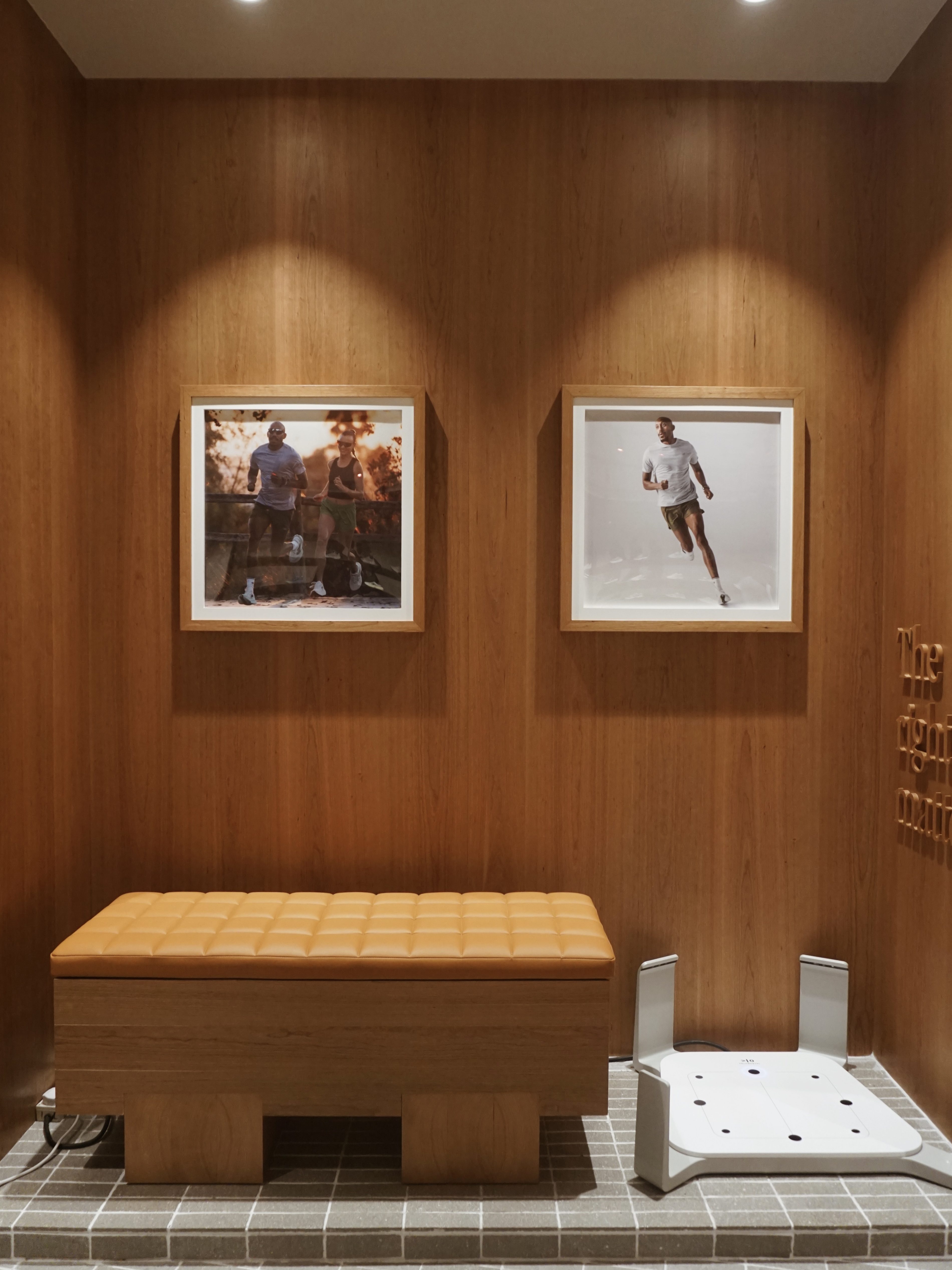 Interior view of a the New Balance Run Hub featuring two framed photos of runners on the wall.