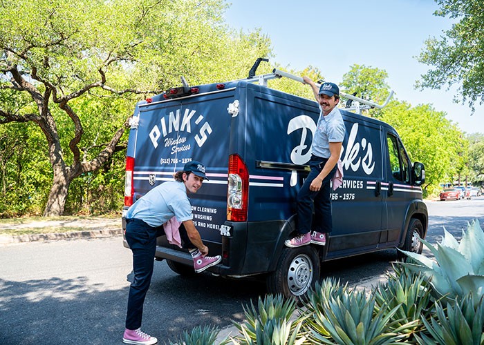 a picture of carter smith and brandon downer standing beside a pink window bus