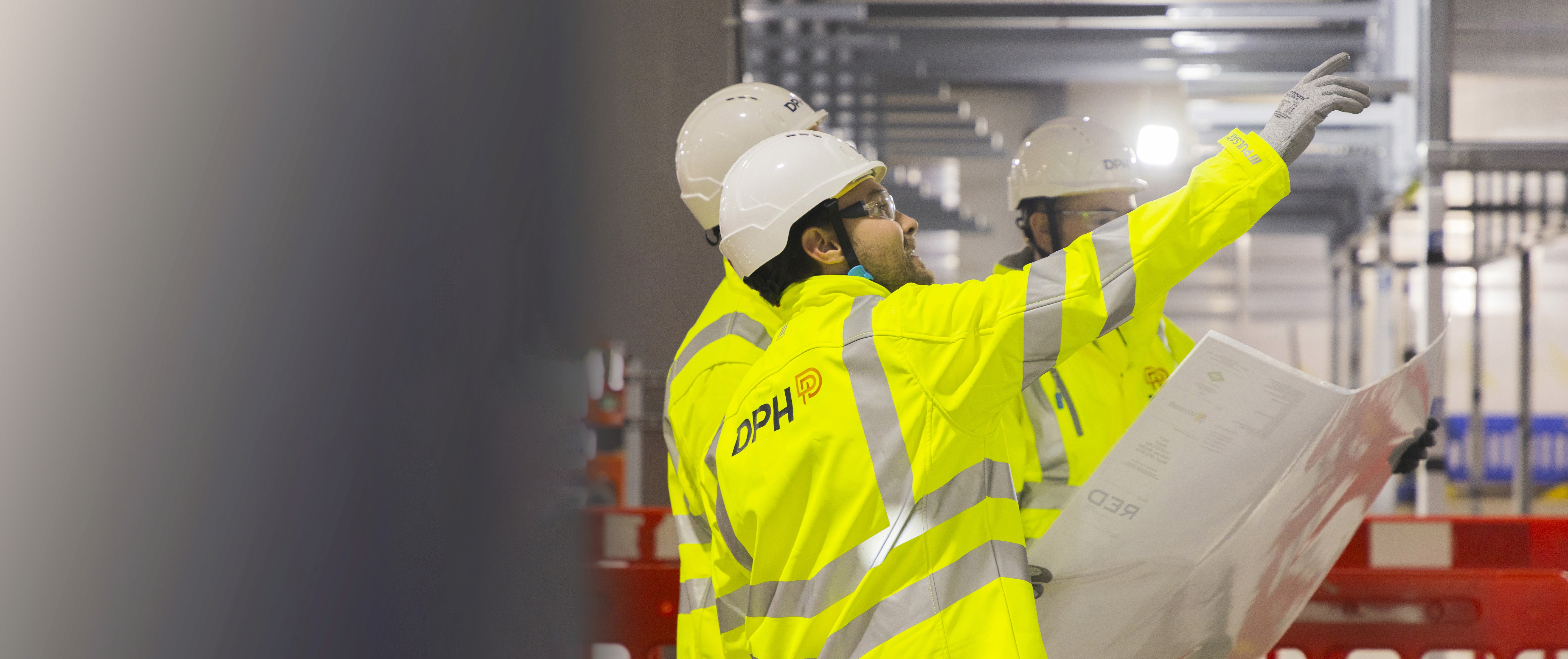 Modern glass building with illuminated interior and reflections at sunset