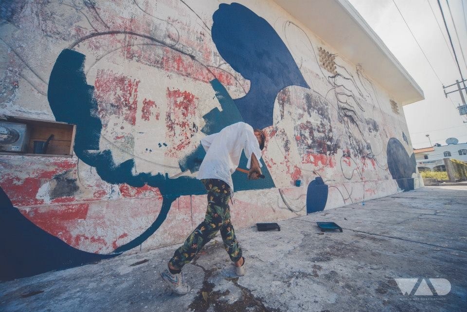 Jason Botkin painting the Jacques Cousteau portrait on scaffolding in Cozumel, Mexico for SeaWalls