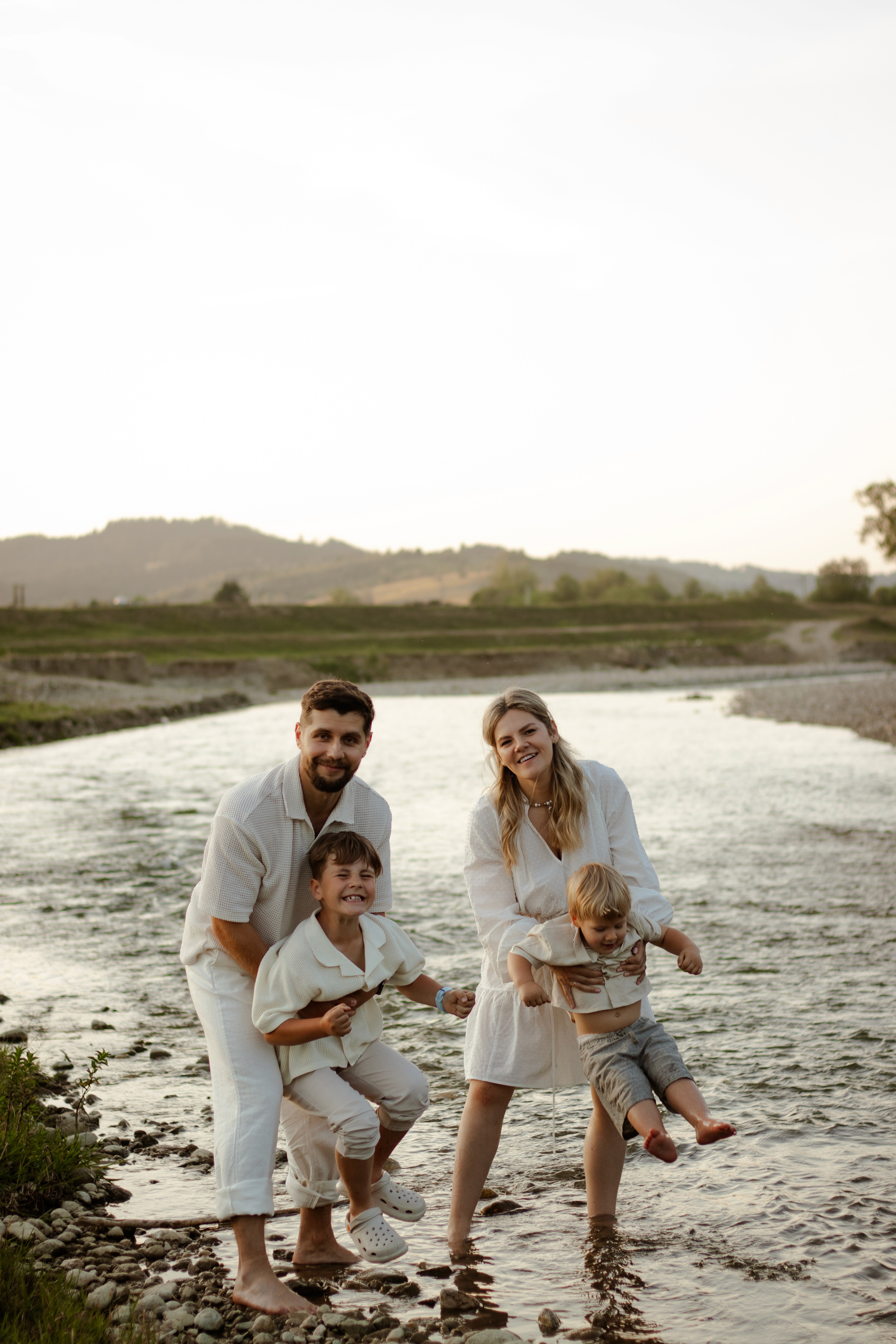 man in white shirt carrying girl in gray shirt