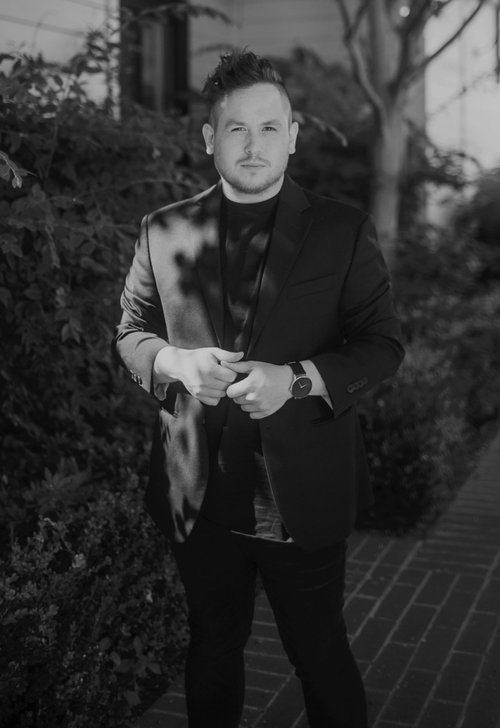 Black and white photo of a man dressed in a styleish suit