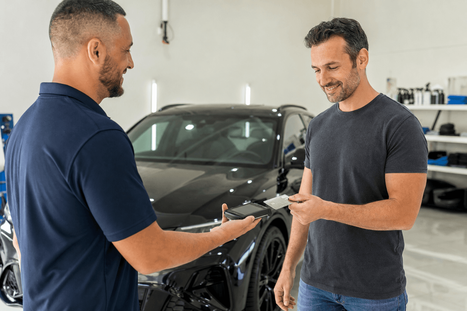 Customer paying a detailing shop by tapping a card on a mobile card reader