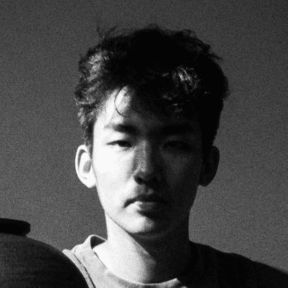 Profile portrait of a man in a white shirt against a light background