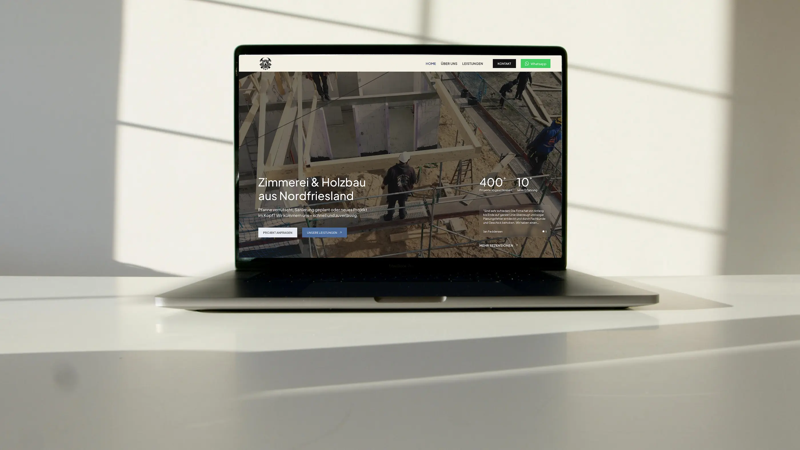 Ein Laptop steht auf einem Tisch der ein Wireframe für eine Website baut
