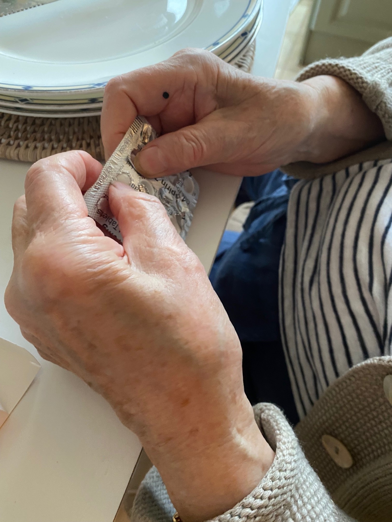 Elderly person opening pill packet 4.