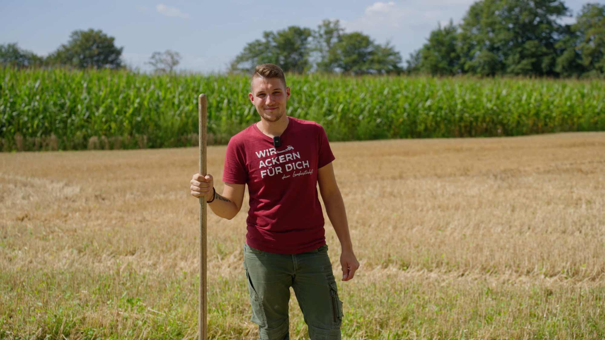 Young man with a tool in a field, ideal for filmproduction concepts in advertising and storytelling through imagefilm.