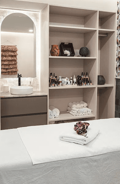 Spa relaxation lounge with two loungers, lanterns and a carved stone wall