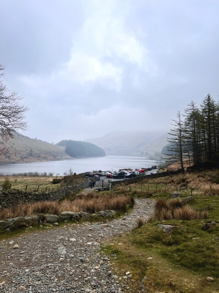 A path leading towards a carpark with Haweswater reservoir in the background.