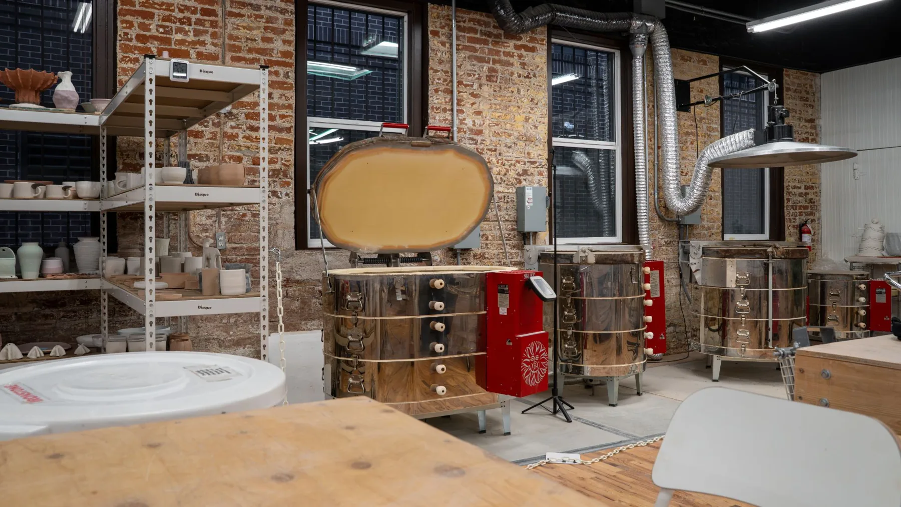 Four Skutt kilns and shelves of bisqueware in the kiln room at Kinship pottery studio