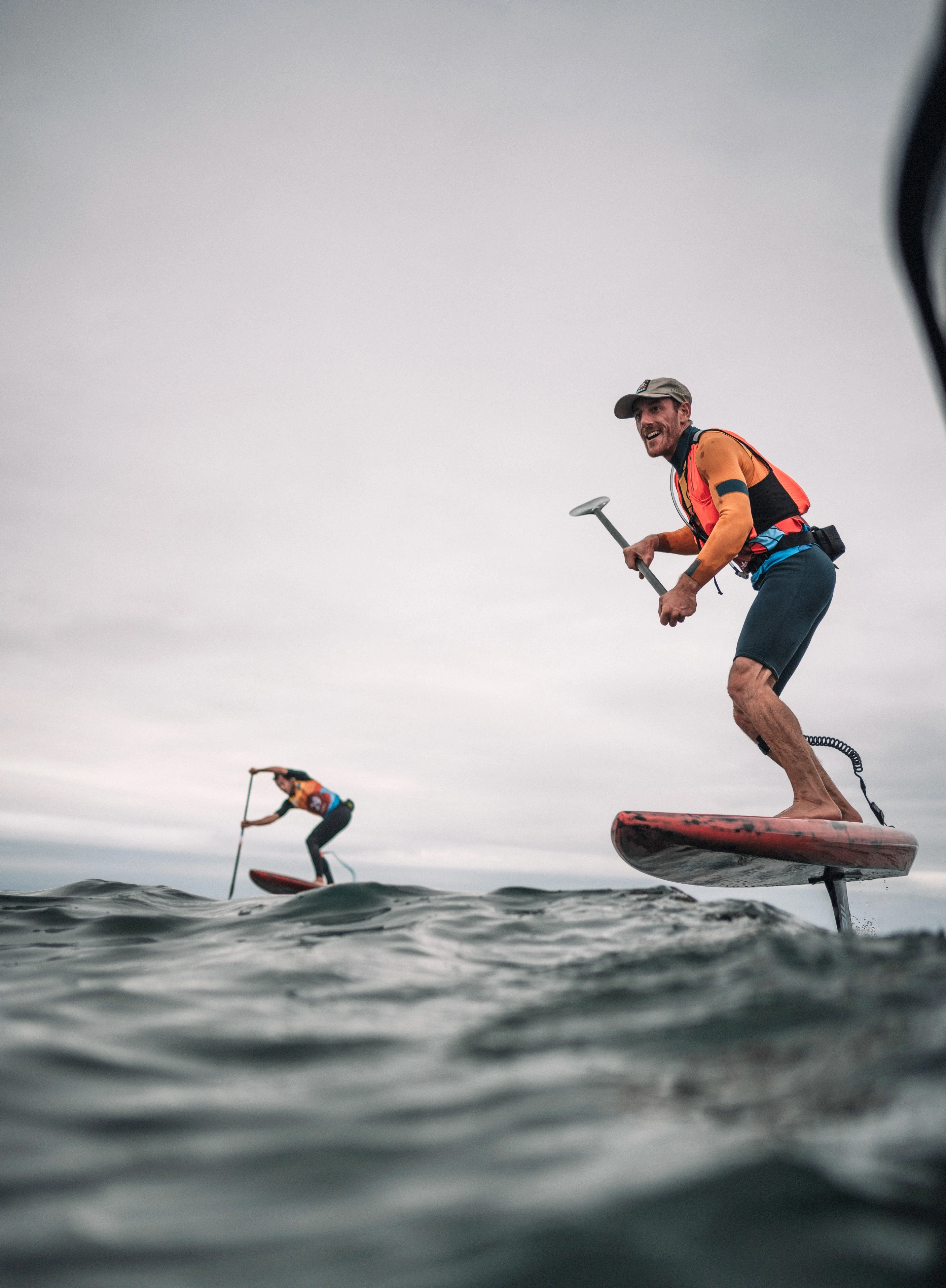 Deux hommes en compétition de paddle foil sur la mer
