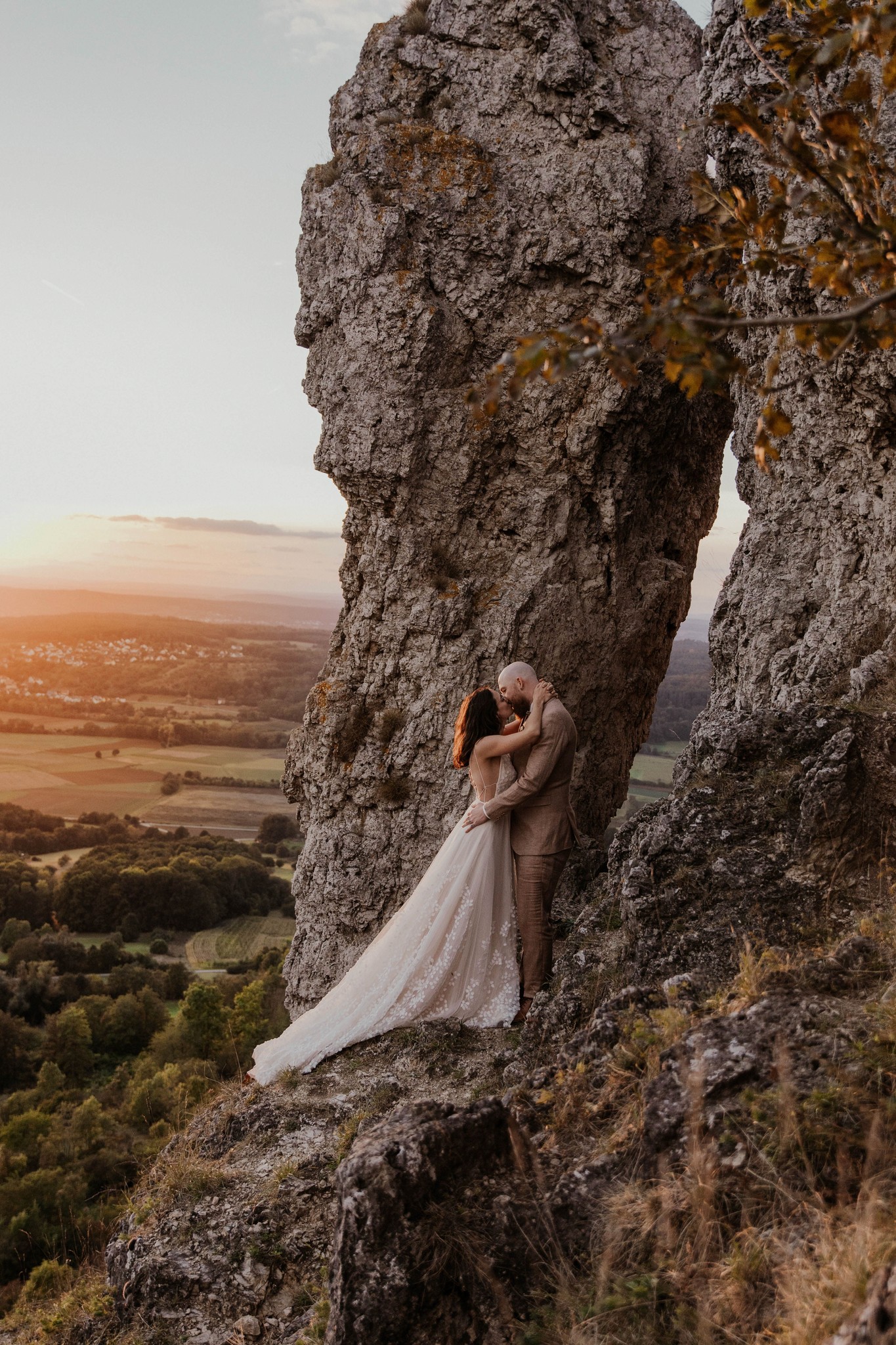 Romantisches Brautpaar-Shooting bei Sonnenuntergang an einer Felsklippe.