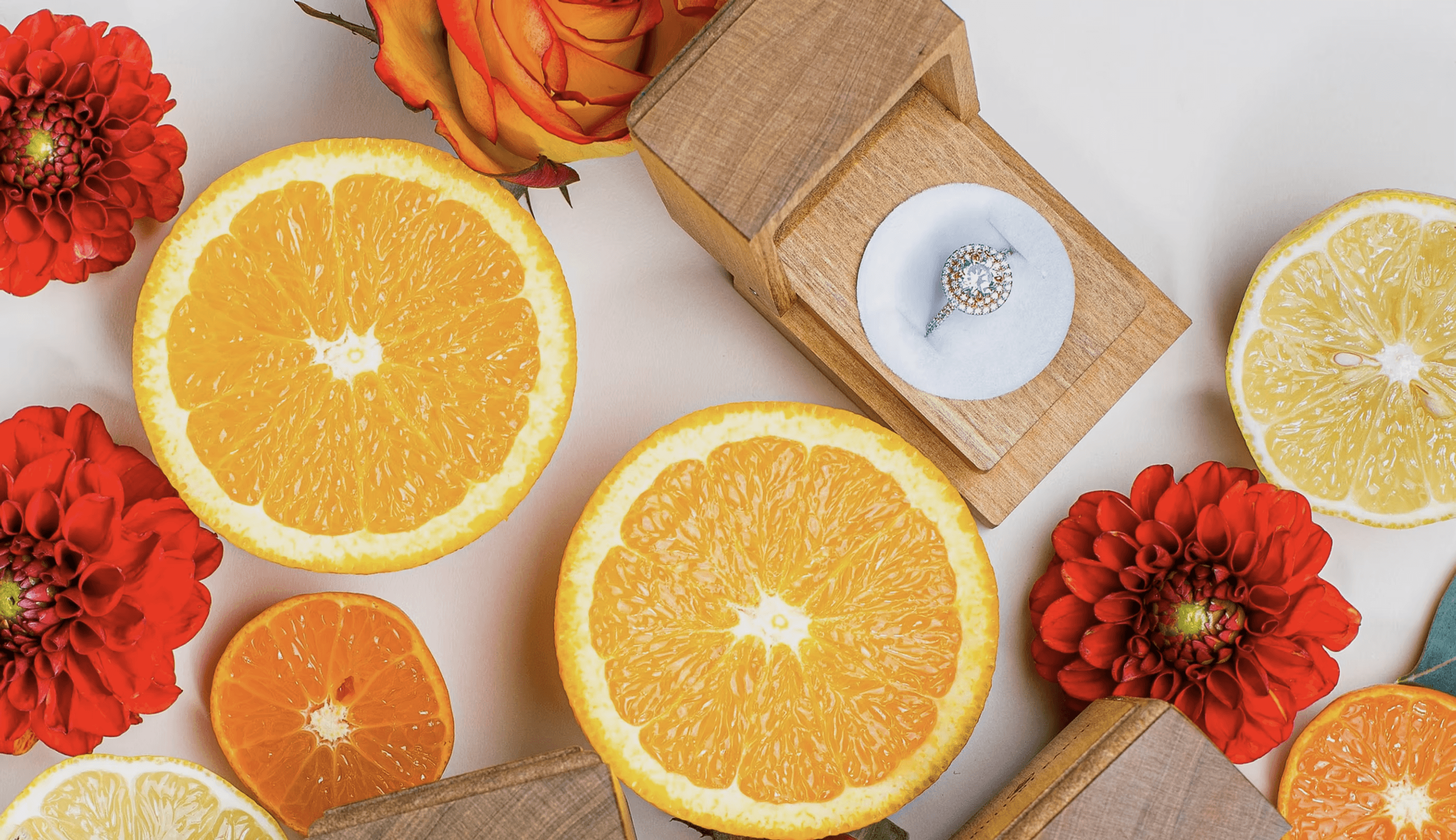 Fruit slices and flowers arrnged on a white tiable.
