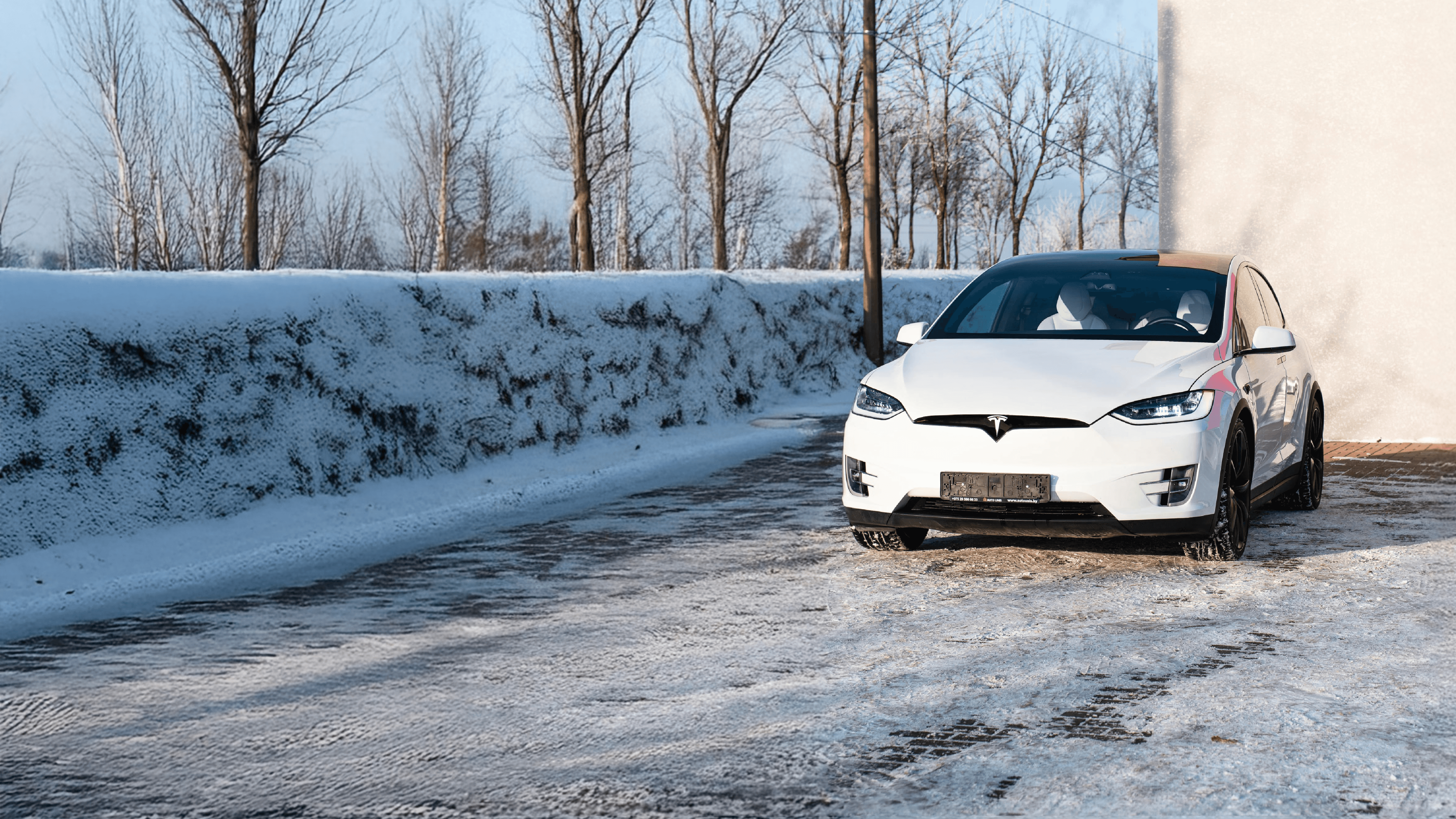 a white car parked in a snowy area