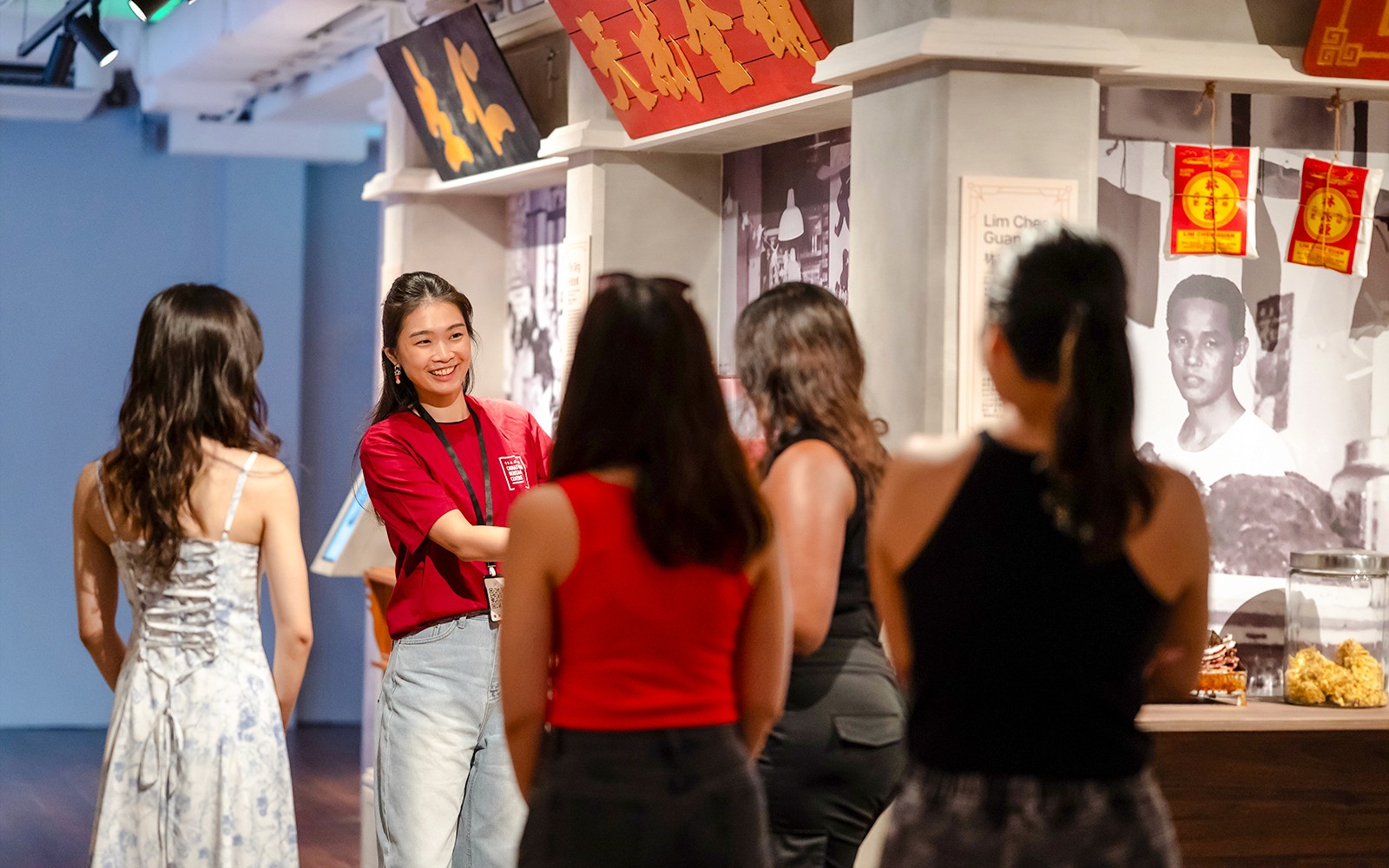 Guide explaining exhibits to a visitor at Chinatown Heritage Centre, Singapore.