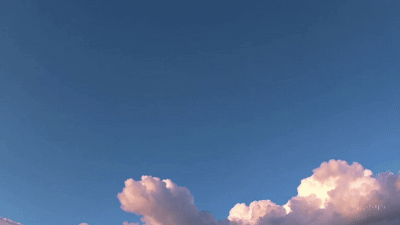 Clear blue sky with fluffy white clouds floating gently, capturing a serene and peaceful atmosphere on a sunny day.