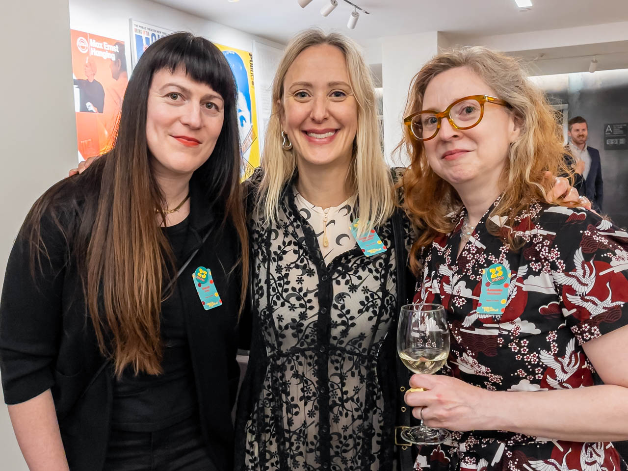 three people at a cocktail party looking at the camera