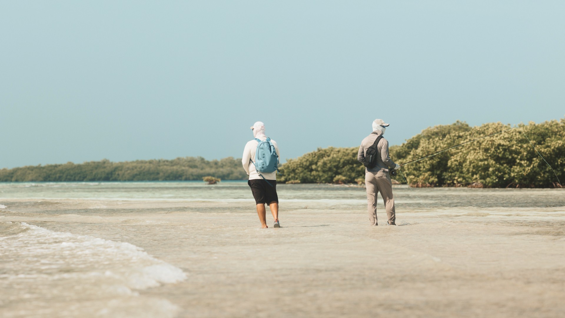 Angler and a fly fishing guide walking in skinny water on a flat outside Placencia