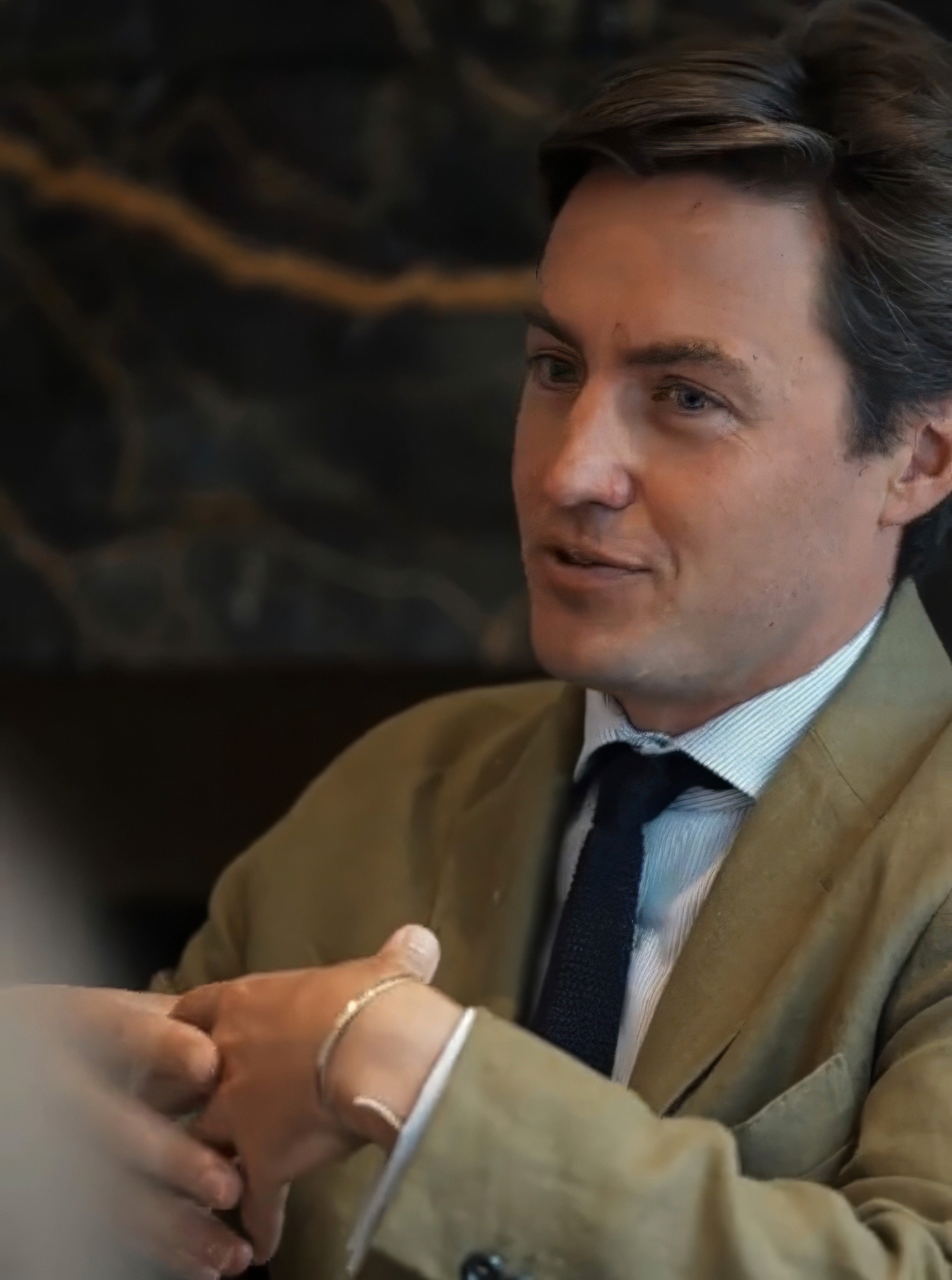 Bride in white dress walking on street, man in background