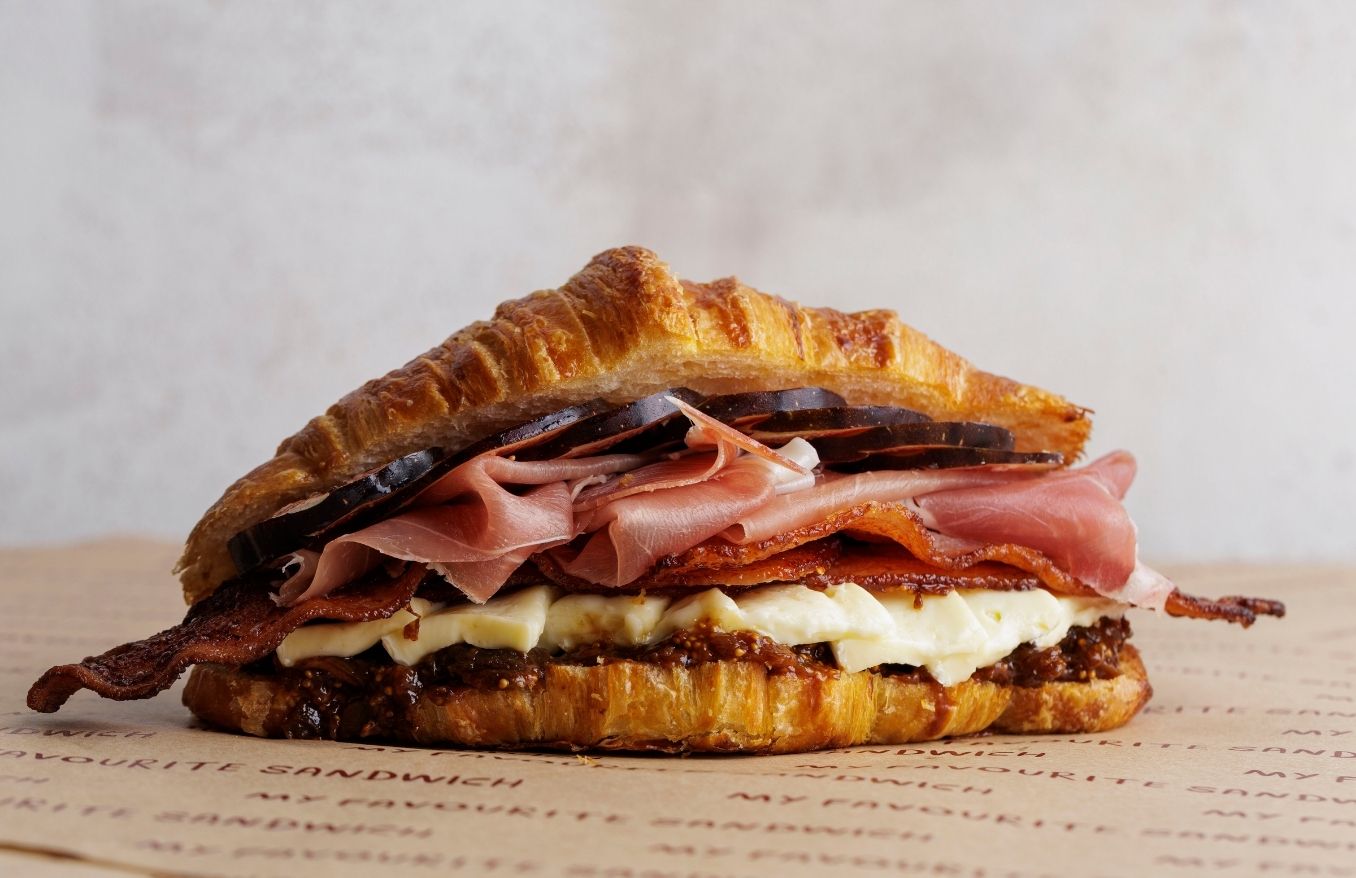 Toasted Butter Croissant, Prosciutto di Parma, brie cheese, fig jam, with crispy Bacon