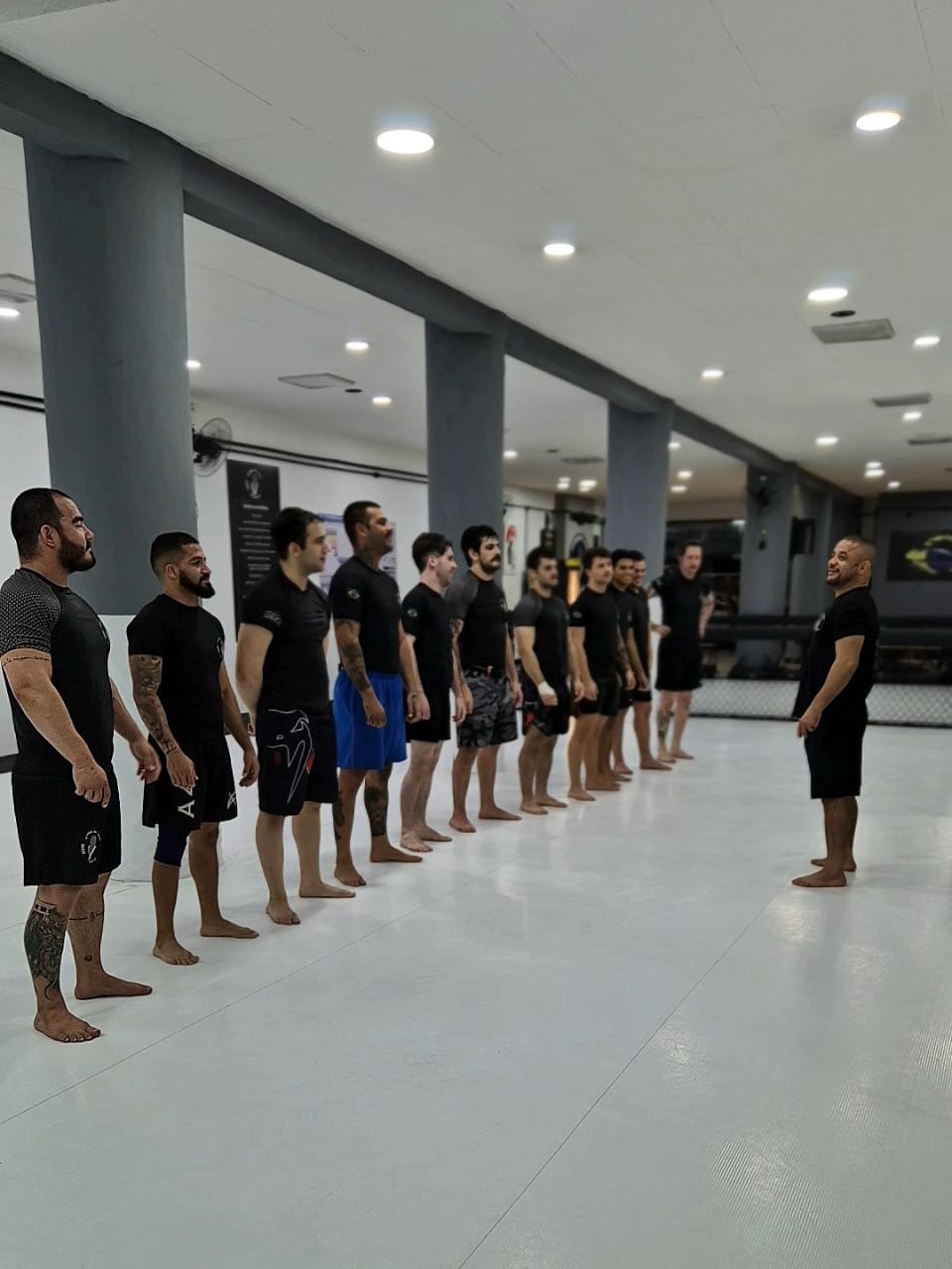 a man standing in a gym holding a rope