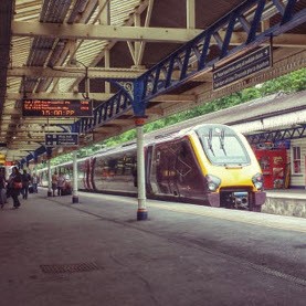 Train stopped at a UK railway station platform suitable for Mainmark UK's rail subsidence solutions